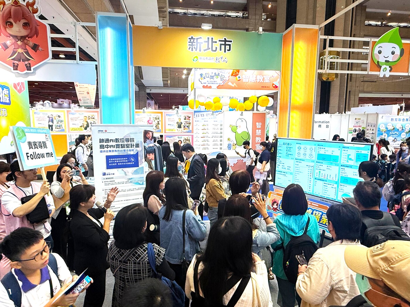 新北市數位學習辦公室主任何春緣於教育科技展現場，向苗栗縣數位學習辦公室團隊介紹圖片