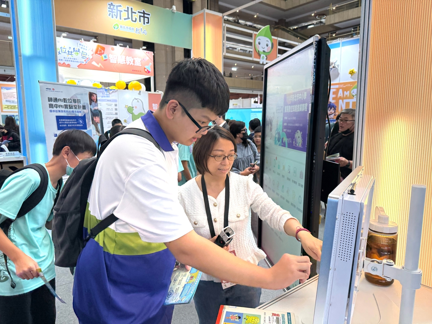 教育科技展展出新北市智慧校園應用，學生現場體驗「智慧租還書系統」，透過掃碼即可圖片