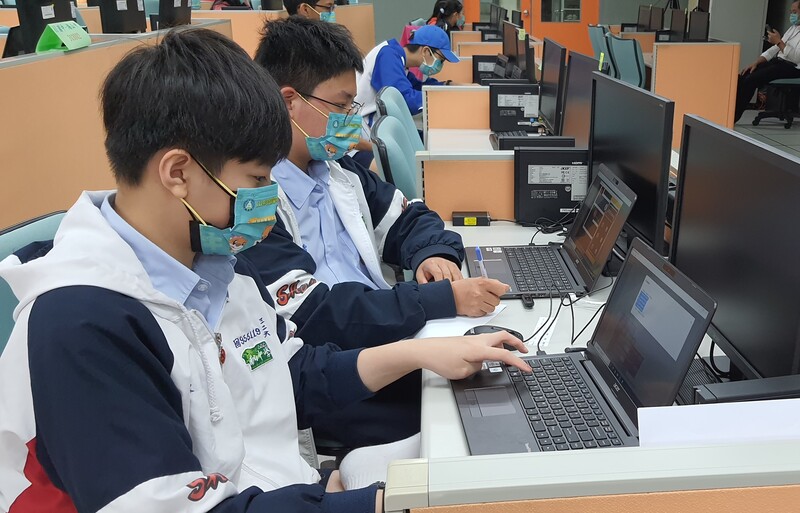 南山中學陳禹丞(左1)、曾緯淳(左2)現場寫程式、訓練AI自走車跑迷宮地圖