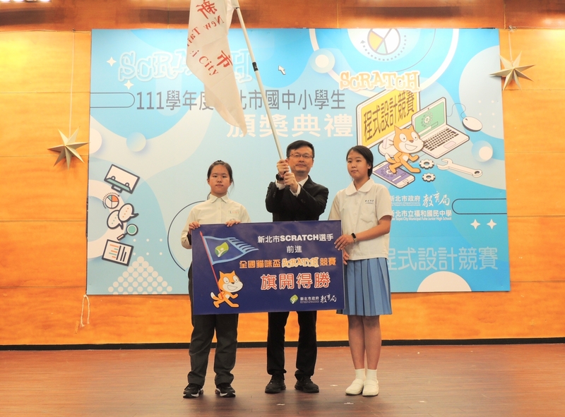 民安國小施羽倢(左)、崇光中學丁瑀涵(右)代表授旗，教育局長張明文鼓勵孩子今年4月參加「112年度全國貓咪盃SCRATCH競賽」，再創佳績